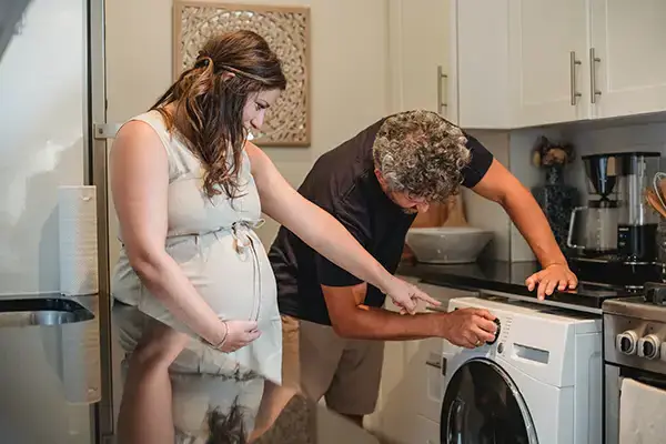 Someone maintaining a washing machine household appliance